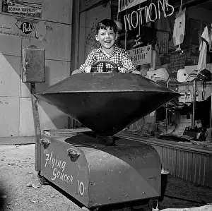 Cheerful Prints: Boy in toy ride outside store