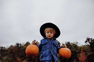 Fall Colors Prints: Boy wearing hat holding pumpkins in fall