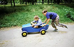 Blur Prints: Two boys playing with pedal car in a park