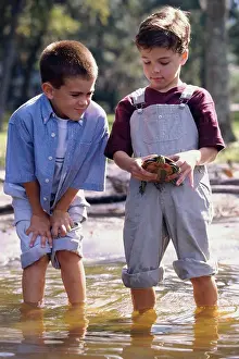 Overalls Prints: Two boys standing in water holding a turtle