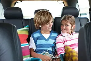 Exhilaration Prints: Brother and sister listening to music in the back of a car