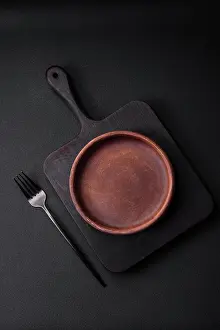 2023 Prints: Empty brown colored ceramic plate on dark concrete background Empty brown colored ceramic plate on dark textured