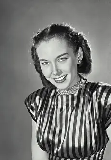 One Young Woman Only Prints: Brunette woman wearing striped silk blouse and beaded necklace smiling