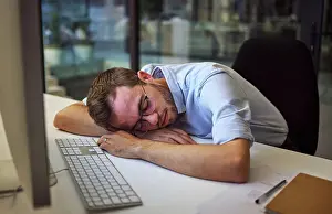 Depressed Prints: Burnout, tired and sleep with a business man sleeping on his desk while working on a computer at a desk in his office