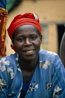 Eastern Prints: Burundi, Cibitoke District, Smiling Woman Sat With Blue Dress And Red Headscarf