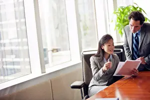 30 To 35 Years Prints: Two business colleague looking over important documents together