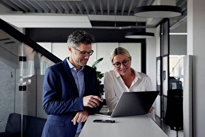 45 To 50 Years Prints: Business colleagues sharing laptop at office
