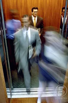 Businesswomen Prints: Businessman and a businesswoman exiting an elevator