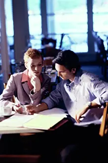 Business Suit Prints: Businessman and a businesswoman sitting in a restaurant talking