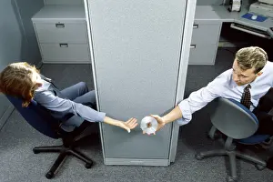 Businesswomen Prints: Businessman handing a compact disk to a businesswoman in an office