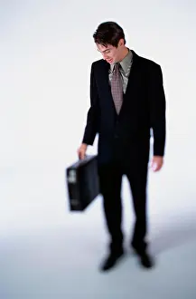 Business Travel Prints: Businessman looking down while holding a briefcase