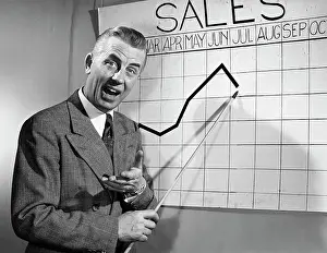 Chart Prints: Businessman pointing at sales chart