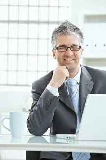 Smart Prints: Businessman thinking Businessman with gray heair thinking over laptop computer