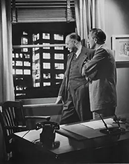 Curiosity Prints: Two businessmen in office looking through window, 1950s