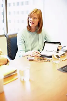 Businesswomen Prints: Businesswoman sitting in a conference room