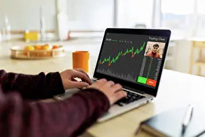 Industry Prints: Businesswoman trading on laptop doing video call with colleague at home