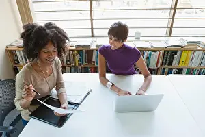 Typing Prints: Two businesswomen working on project in office