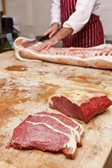 Knife Prints: Butcher carving meat in shop