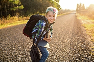 One Boy Only Prints: Canada, Ontario, Smiling boy (8-9) with books on rural road at sunset