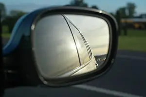 Cinematic Prints: Car side mirror reflecting road and landscape under a soft, golden sunset. Oregon, USA