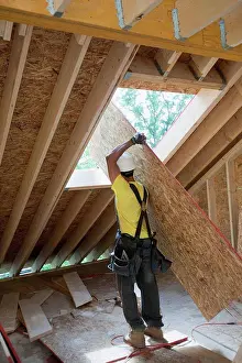 Manual Worker Prints: Carpenter lifting a roof panel at a construction site