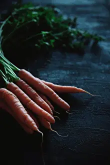 Vegetables Prints: A carrot with stalk on a black background