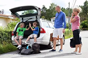 Dads Prints: Caucasian couple looking at happy sons sitting in car trunk before going for picnic