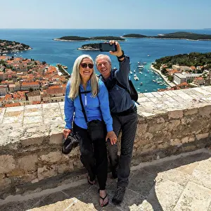 Baby Boomer Prints: Caucasian couple posing for cell phone selfie with scenic view of ocean