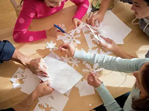 Father Prints: Caucasian family cutting out paper snowflakes