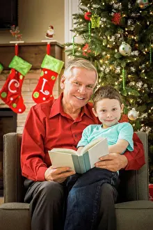 Story Prints: Caucasian grandfather reading to grandson at Christmas