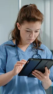 Assistant Prints: Caucasian nurse using digital tablet with touch screen
