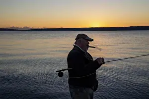 Smoking Prints: A Caucasian senior fly fisherman enjoys a sunrise cigar before fly fishing for searun coastal cutthroat trout