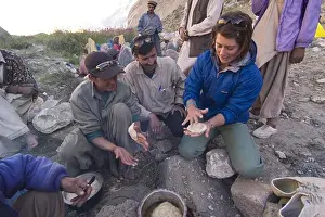 Small Group Of People Prints: A caucasian woman making chapati bread with some Balti men in Pakistan