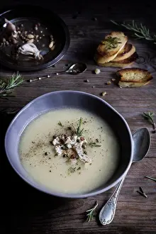 Vegetables Prints: Cauliflower cream soup in bowl with grilled bread slices on wooden table