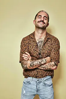 Macho Prints: Cheerful fashionable male model with tattoos wearing trendy leopard shirt
