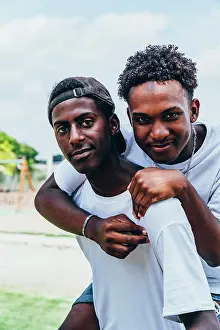 Cheerful Prints: Cheerful hugging African American young men looking at camera and gesturing