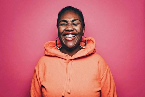 Jackets Prints: Cheerful mid adult woman wearing orange hooded shirt over pink background