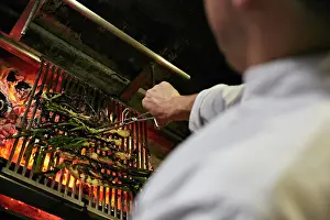 Prepare Prints: Chef turning Catalan Calçots cooking on charcoals