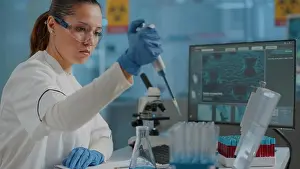 Technician Prints: Chemist working on experiment with micro pipette and beaker