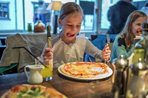 Concentrate Prints: A child about to eat a delicious pizza in a restaurant