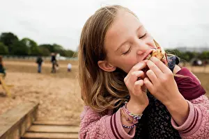 Gradeschooler Prints: child enjoying street food whilst at a festival