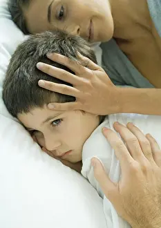 Cuddly Prints: Child lying in bed, parent's hands on head and shoulder