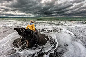 People In Nature Prints: Child sitting on tree stump in stormy water at New Zealand beach