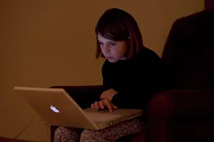 Upper Body Prints: A child works on a laptop computer, Maine, USA