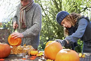 Knife Prints: Children carving pumpkins together outdoors, belmonthouse, UK