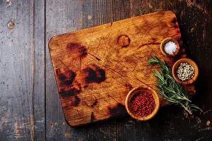 Copyspace Prints: Chopping cutting kitchen board, salt, pepper and rosemary on dark wooden background