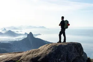 Coast Prints: Climber enjoying beautiful view to city from rocky mountain top