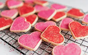 Festive Prints: Close up of many decorated heart shaped cookies on cooling rack