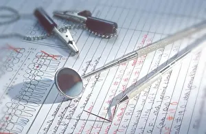 Assistant Prints: Close up of dental tools lying on a patient dental chart