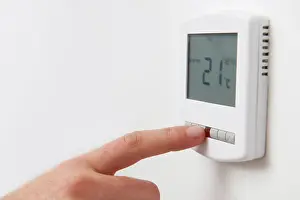 Adjusting Prints: Close Up Of Hand Adjusting Digital Central Heating Thermostat